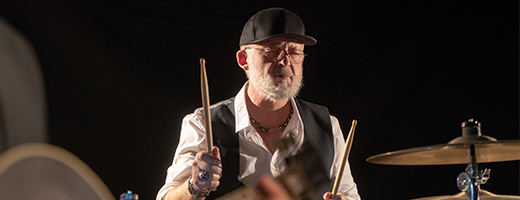 Image of senior-aged man playing the drums